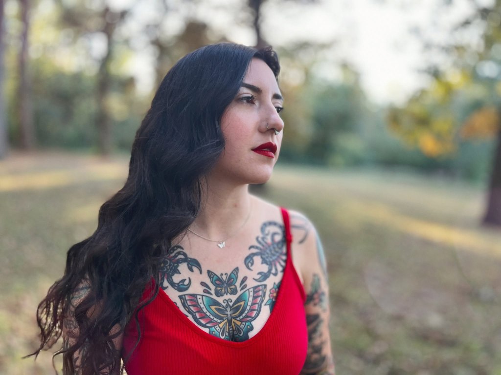 A profile view of musician Heather Hammers in a red tank top. 