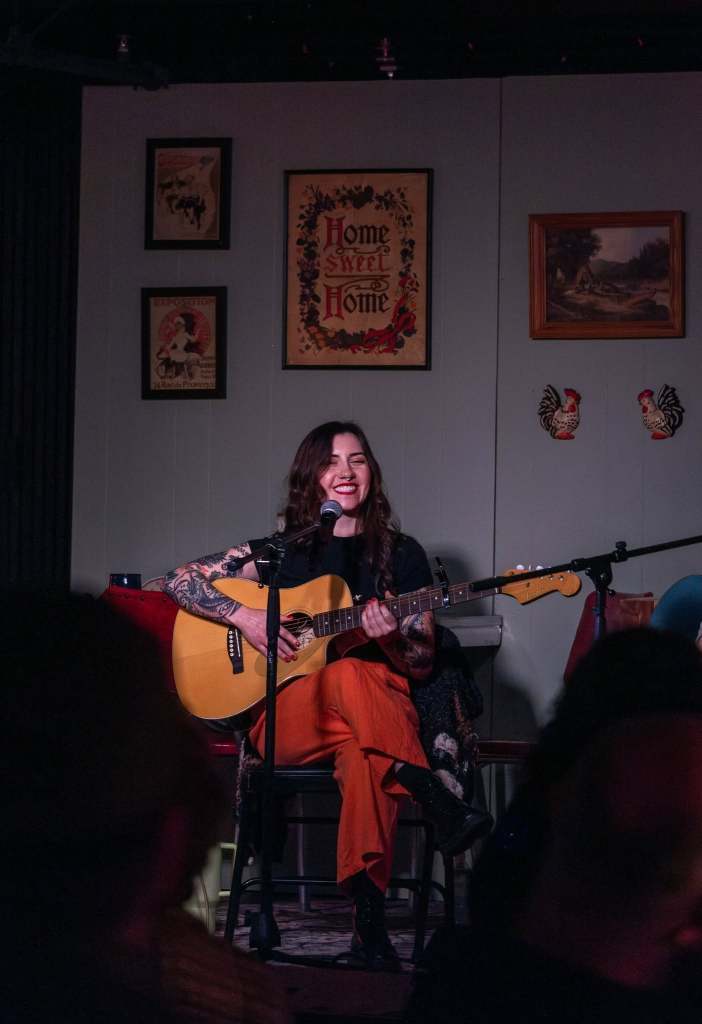Musician Heather Hammers playing guitar on stage.